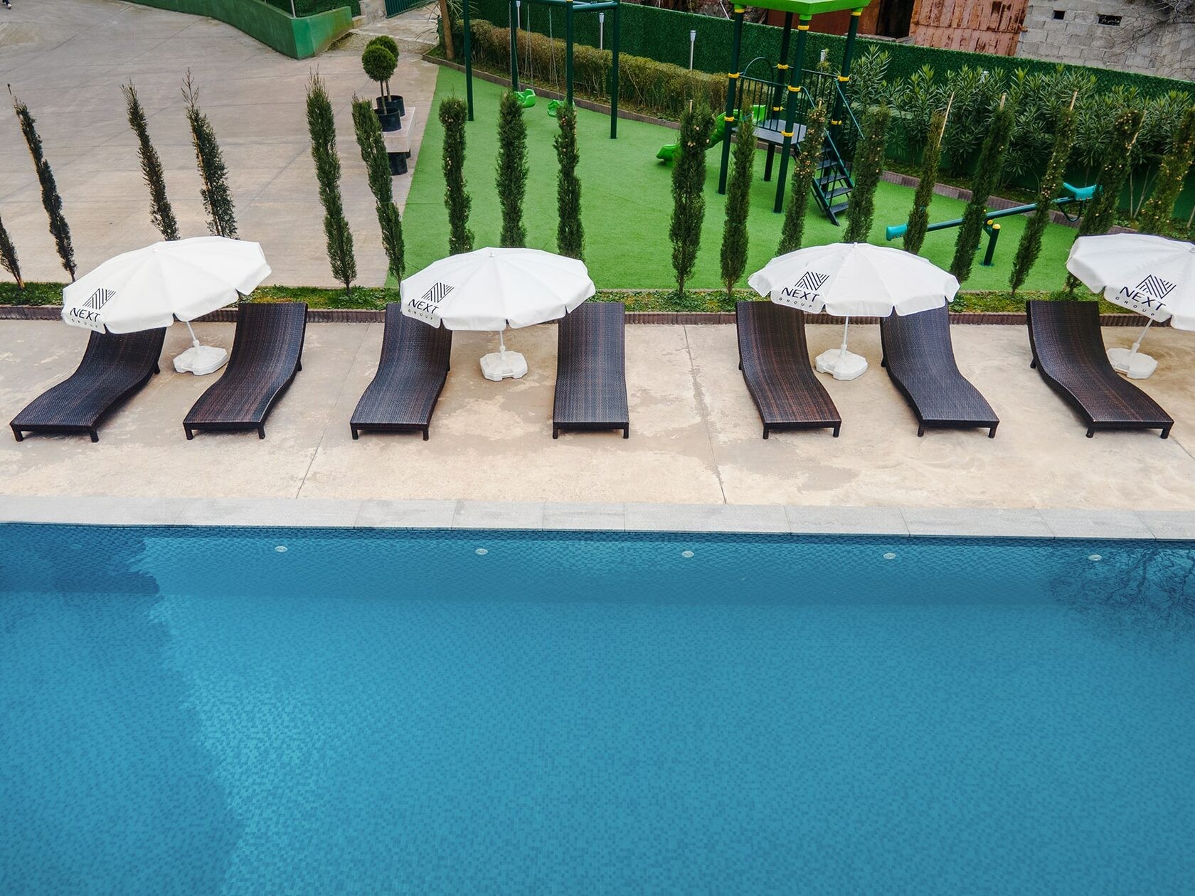 NEXT Green outdoor swimming pool, loungers and gardens